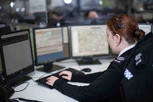 A police staff apprentice working at a computer