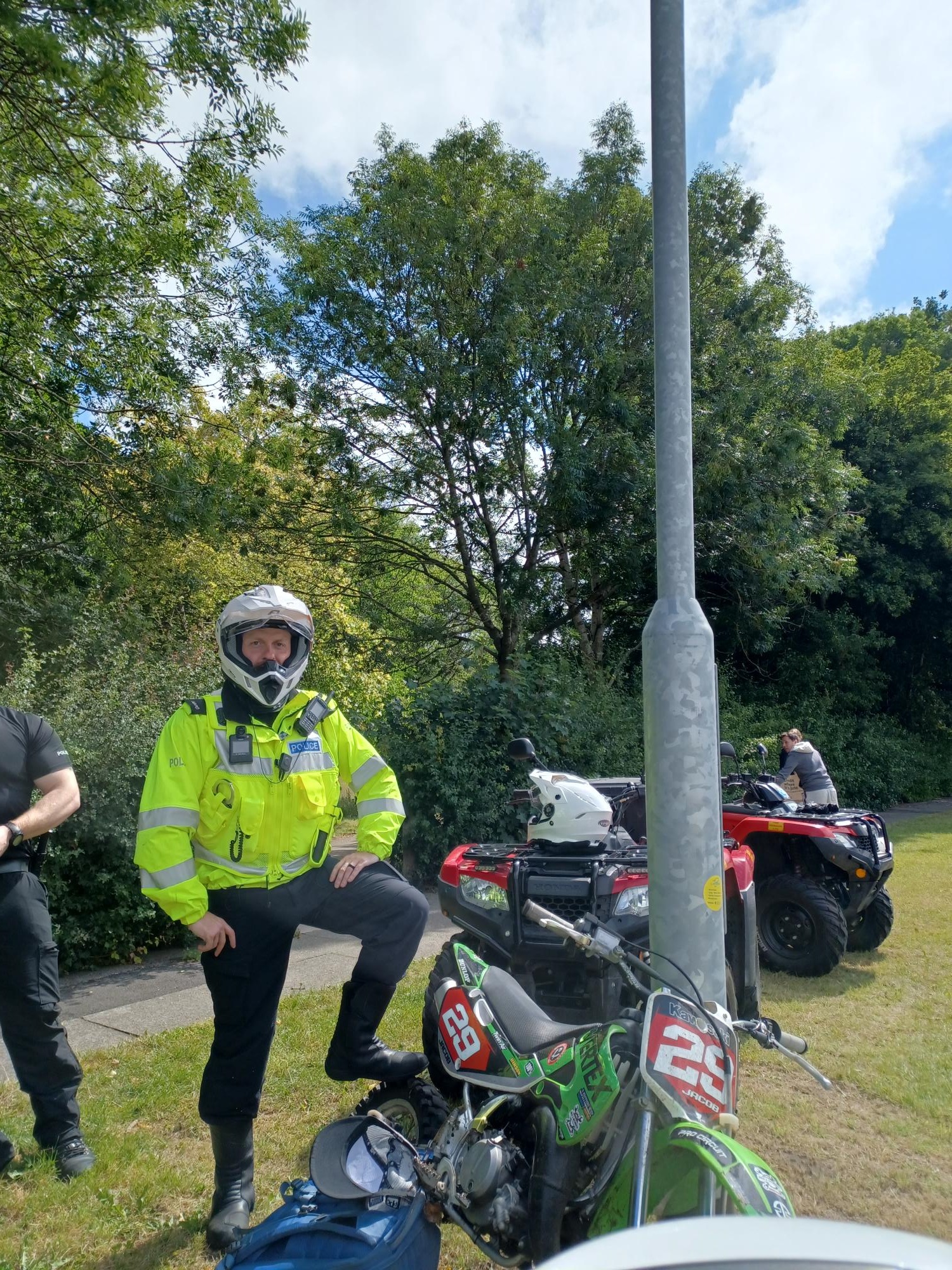 AN OFFICER STANDING WITH OFFROAD BIKES